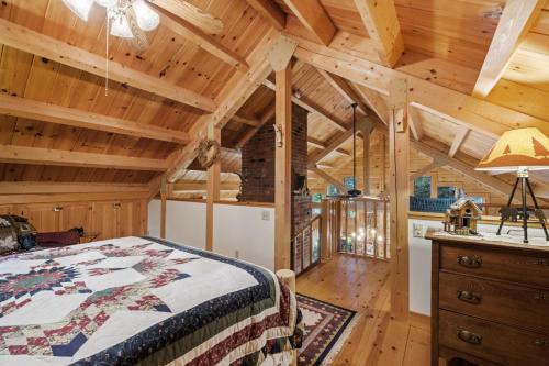 a bedroom in a log cabin with a bed and a desk at Lakefront Log Cabin on 2 acres in Washington