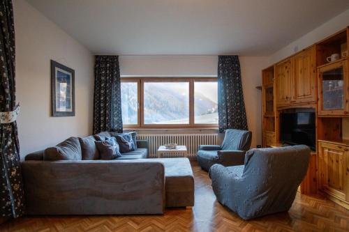 a living room with a couch and two chairs at Villa Maria - Appartamento vista montagna in Moena
