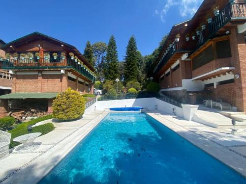 a swimming pool in front of a house at Villa San Francisco in Valle de Bravo