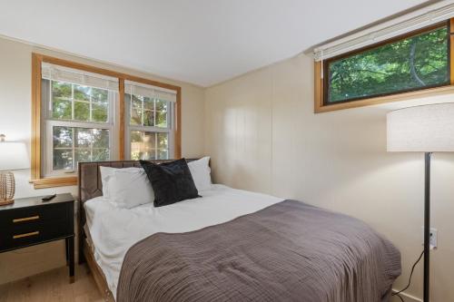 a bedroom with a bed and two windows at Intimate Cabin Private Dock in Washington