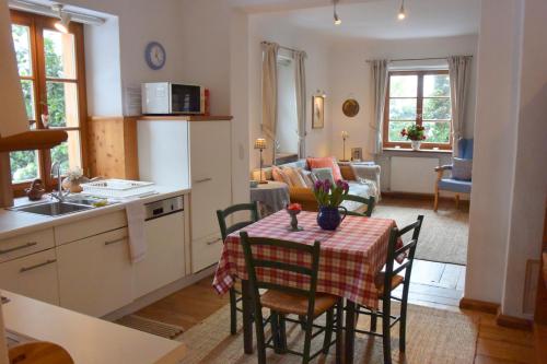 a kitchen and living room with a table and chairs at Sonnwirtstöckl am See in Sankt Gilgen