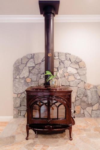 a wood stove in front of a stone wall at Luxury House, Walk to Downtown or Pioneer Park in Nevada City