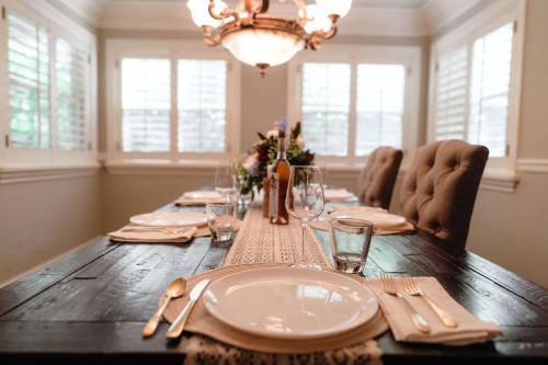 a dining room table with plates and glasses and a chandelier at Luxury House, Walk to Downtown or Pioneer Park in Nevada City