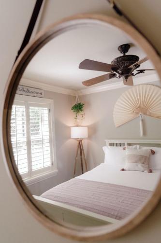a mirror reflecting a bedroom with a bed and a ceiling fan at Luxury House, Walk to Downtown or Pioneer Park in Nevada City