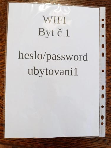 a white sign with the words wifi byretto and hosol password at LEVNÉ UBYTOVÁNÍ Ústí nad Labem in Ústí nad Labem