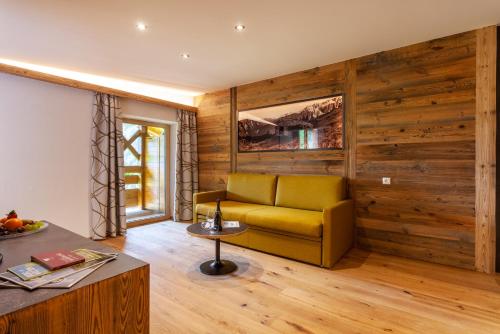 a living room with a yellow couch and wooden walls at Hotel Panorama in Fleres