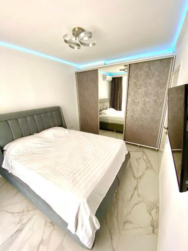 a bedroom with a white bed with a mirror at Summerland Seaview Apartments in Mamaia