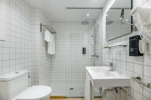 Un baño blanco con inodoro y lavabo. en Hotel Vibra Bossa Flow - Adults only, en Playa d'en Bossa