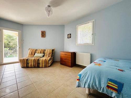 une chambre avec un lit, un canapé et une fenêtre dans l'établissement Spacieuse et confortable villa avec piscine - L'Impériale, à La Tremblade