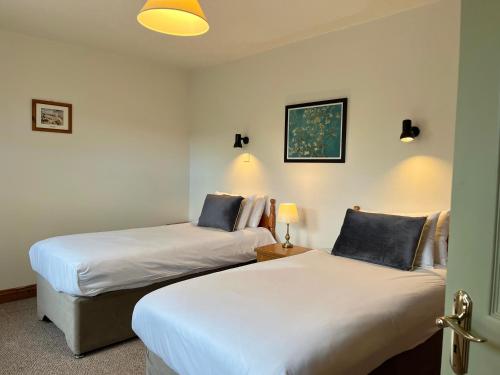 two beds sitting next to each other in a room at Atlantic View Cottages in Doolin