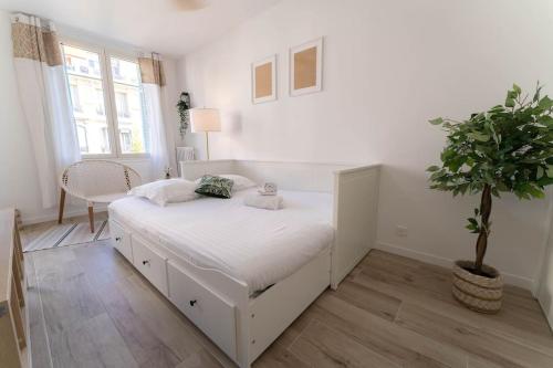 - une chambre avec un lit blanc et une plante en pot dans l'établissement PF1 Studio terrasse, Centre, Proche Tramway, à Nice