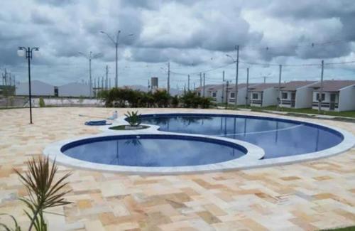 a large swimming pool in the middle of a yard at Casa Jardim PINHEIROS in Maceió
