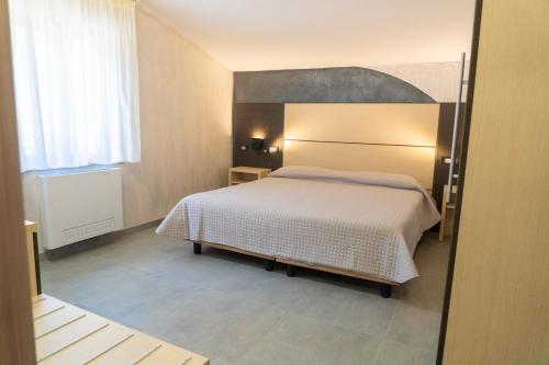a bedroom with a bed with a large headboard at Albergo della Posta in Taverna