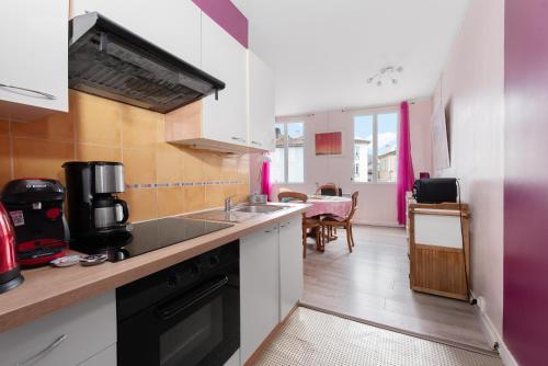 une cuisine avec un évier et une cuisinière dans l'établissement Duplex centre Saint-Girons, à Saint-Girons