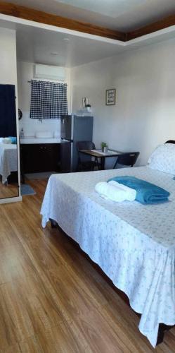 a bedroom with a large bed and a table at Point Gate Inn in Bacolod