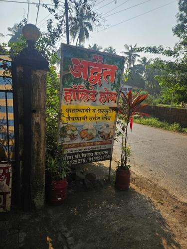 a sign on the side of a road with plants at Advait Holiday Home in Nagaon