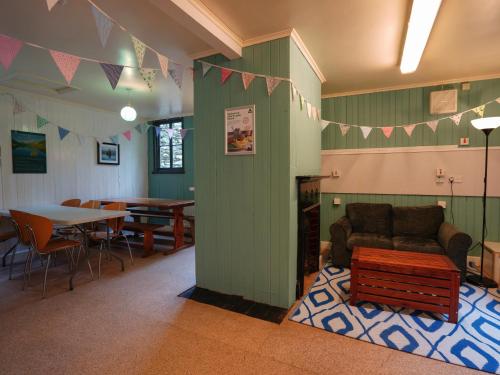 a living room with a couch and a table and chairs at YHA Hawkshead in Hawkshead