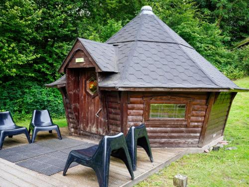 a small wooden cabin with four chairs on a deck at YHA Hawkshead in Hawkshead