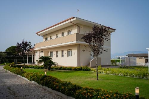 a large white building with a tree in front of it at Villa Zefiro - Suites & Events in Battipaglia