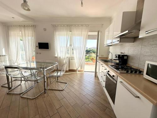 una cucina con tavolo in vetro e piano di lavoro di Terrazza sul Parco a Roma