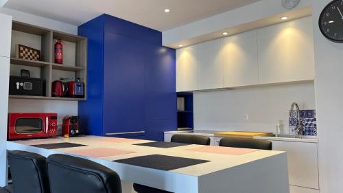 une cuisine avec une table, des chaises et un mur bleu dans l'établissement La Vie en Rose & Bleue - Louez L'Esprit Libre !, à Bussy-Saint-Georges