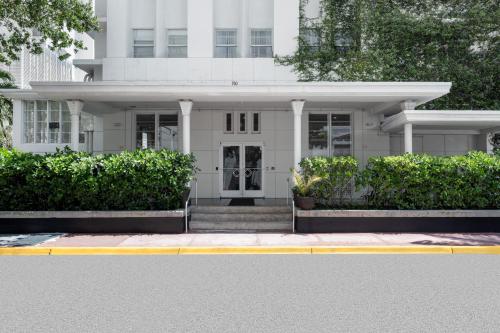 a white house with bushes in front of it at Townhouse Hotel, BW Signature Collection in Miami Beach