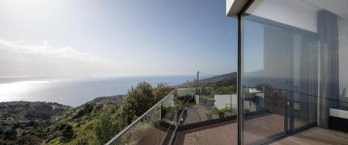 a view of the ocean from the balcony of a house at Villa Panorâmica III in Arco da Calheta