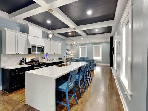a kitchen with white cabinets and a large island with blue chairs at Blue Lagoon in Galveston