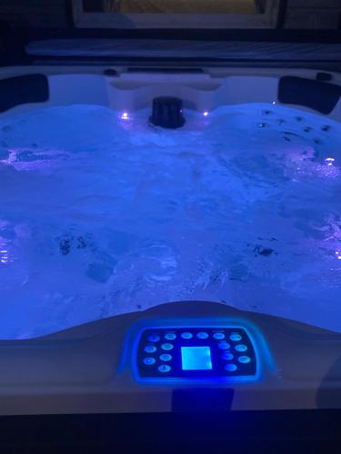 a remote control sitting in a tub with blue lights at Gîte Les Chardons Bleus , les pieds dans l’eau in Pleubian