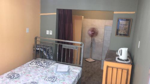 a small bedroom with a bed and a fan at TERRAZAS DEL SUR in Ezpeleta