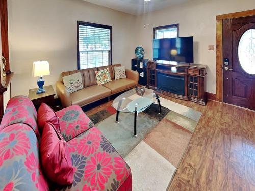 a living room with a couch and a tv at Hidden Haven in Galveston