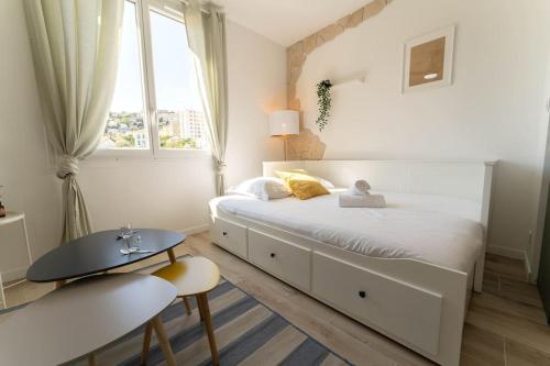une chambre blanche avec un grand lit et une fenêtre dans l'établissement PF2 Studio cosy, Proche Tramway, à Nice