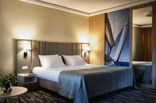 a hotel room with a large bed and a window at Hotel Dom Zdrojowy Resort & SPA - Destigo Hotels in Jastarnia