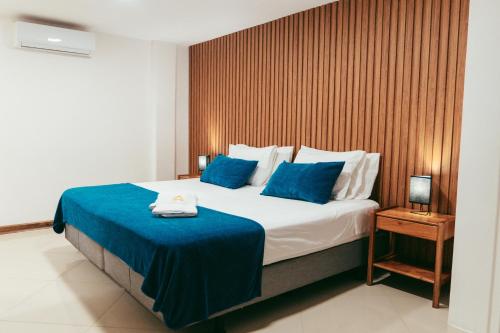 a bedroom with a large bed with blue sheets at Fernandina Hotel & Spa in Puerto Ayora