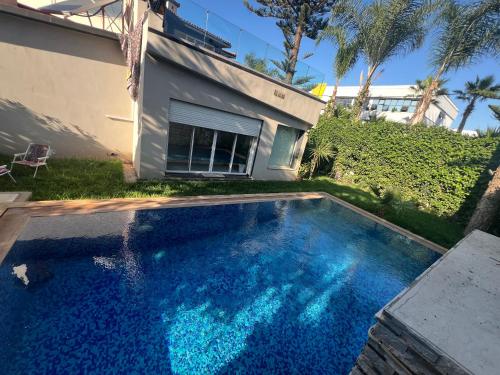 a swimming pool in front of a house at Villa Lalla Laroussa in Kenitra
