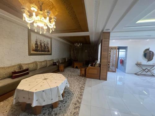 a living room with a table and a couch at Villa Lalla Laroussa in Kenitra