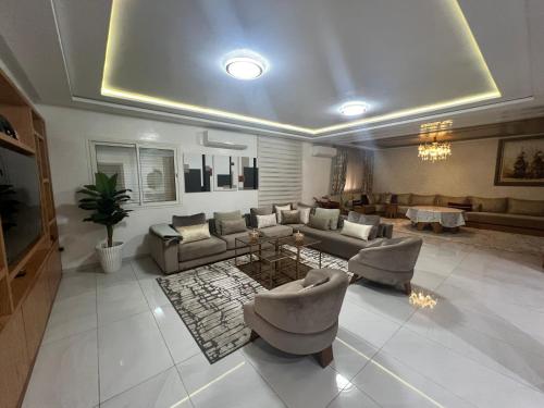 a large living room with couches and a table at Villa Lalla Laroussa in Kenitra