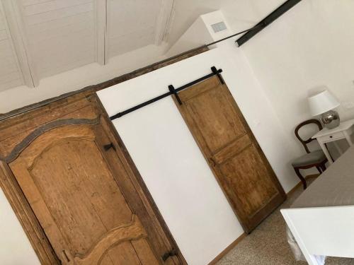 a pair of wooden doors in a room at Cà Bastianet - centro storico in Ivrea