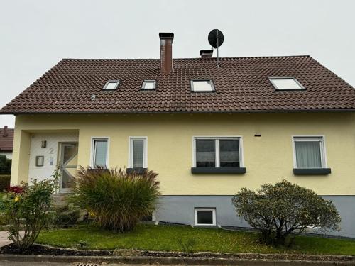 a yellow house with a brown roof at Ferienwohnung Henke in Frickenhausen