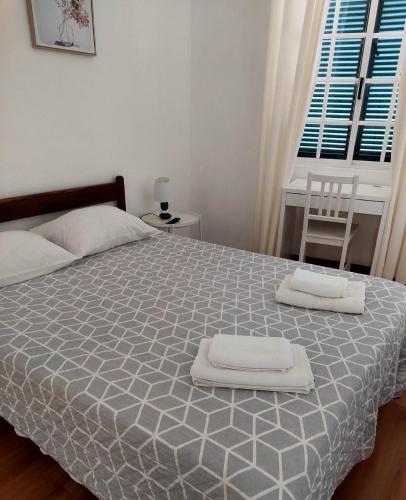 a bedroom with a bed with two towels on it at Hospedaria Pôr do Sol in Funchal