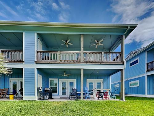 una casa azul con balcón y patio en Copano Coastal Gem, en Rockport