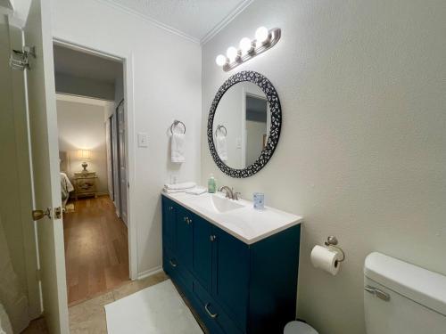 a bathroom with a blue sink and a mirror at Varena Condo in Lake Charles