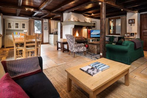 un salon avec un canapé et une table dans l'établissement Chalet Du Guide, à Les Allues
