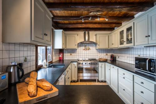 a kitchen with white cabinets and a black counter top at Chalet Du Guide in Les Allues