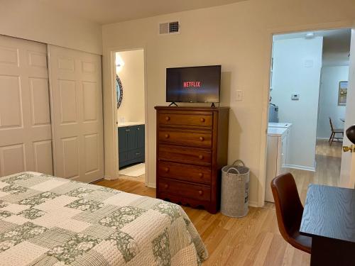 a bedroom with a bed and a tv on a dresser at Varena Condo in Lake Charles