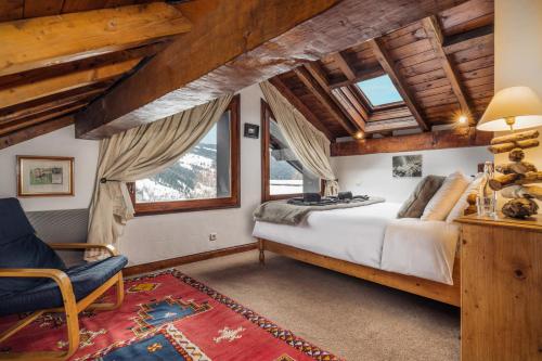 a bedroom with a large bed and a chair at Chalet Du Guide in Les Allues