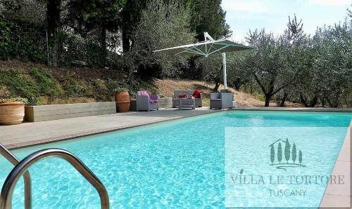 una piscina con sillas y sombrilla en Villa Le Tortore privata lusso piscina relax Siena, en Siena