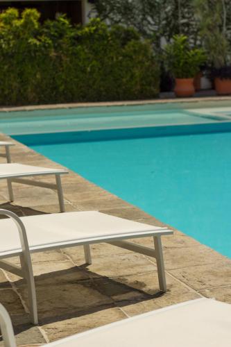 a white bench sitting next to a swimming pool at San Trópico Boutique Hotel & Peaceful Escape in Puerto Vallarta
