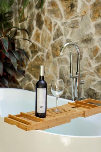 a bottle of wine and a glass on a wooden tray at San Trópico Boutique Hotel & Peaceful Escape in Puerto Vallarta