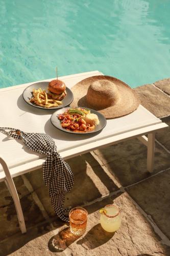 two plates of food on a table next to a pool at San Trópico Boutique Hotel & Peaceful Escape in Puerto Vallarta